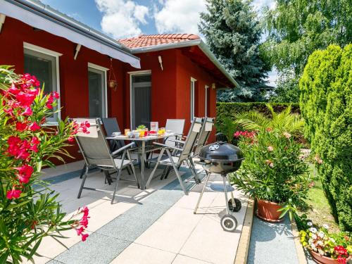 a patio with a grill and a table and chairs at Holiday Home Sunshine by Interhome in Balatonszemes