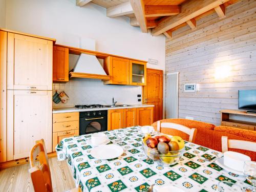 a kitchen with a table with a bowl of fruit on it at Apartment Pensione Villa Belfiore-2 by Interhome in Ronzone