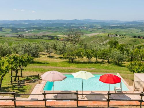 ein Pool mit zwei Sonnenschirmen darüber in der Unterkunft Holiday Home Podere Santa Lucia by Interhome in Volterra