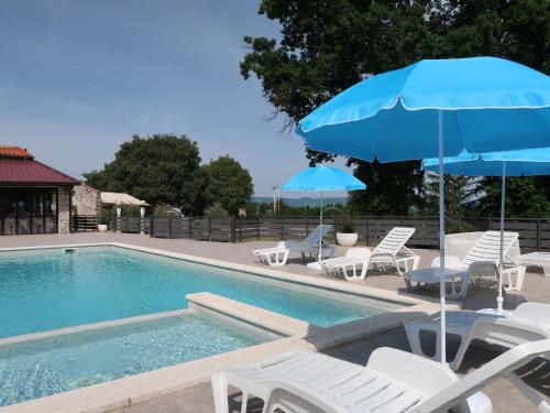 a swimming pool with chairs and umbrellas next to a pool at Holiday Home Rotonda - LBN304 by Interhome in Kršan