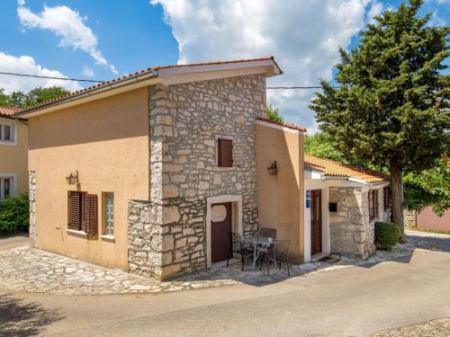 a small stone house with a table in front of it at Holiday Home Rotonda - LBN304 by Interhome in Kršan