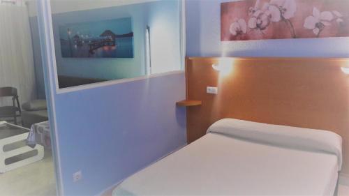 サロウにあるApartamentos TSS Alboranの青い壁のベッドルーム1室(ベッド1台付)