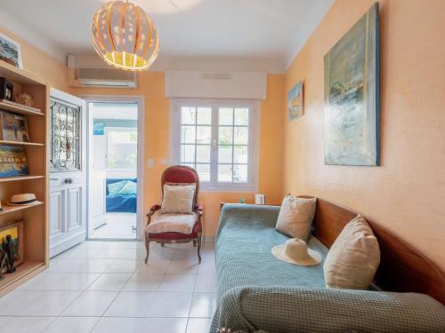 een woonkamer met een bank en een stoel bij Holiday Home Maison Poincaré by Interhome in Saint-Aygulf