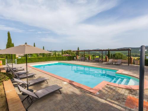 a swimming pool with chairs and an umbrella at Apartment Girasole-3 by Interhome in Montecatini Val di Cecina