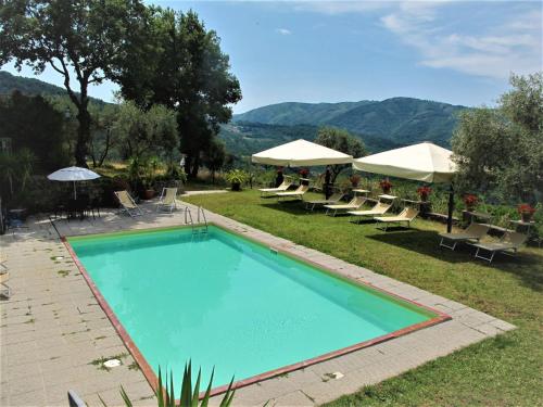 a swimming pool with lounge chairs and umbrellas at Holiday Home Fienile by Interhome in Linari