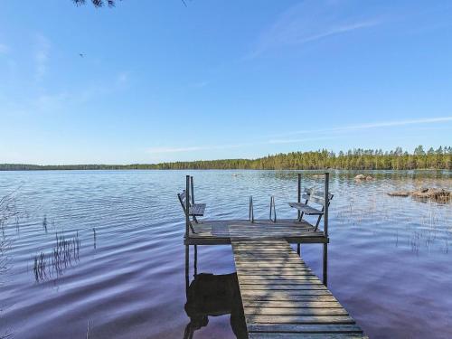 un quai avec deux chaises assises au sommet d'un lac dans l'établissement Holiday Home Haapala by Interhome, à Soini