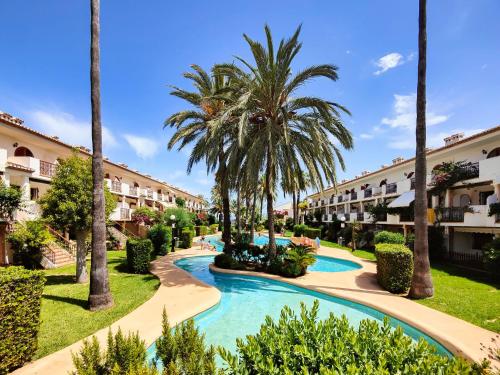 a resort with a swimming pool and palm trees at Apartment Bahia Azul in Denia