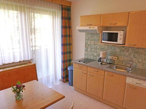une petite cuisine avec une table et un four micro-ondes dans l'établissement Apartment Diana-1 by Interhome, à Pettneu am Arlberg