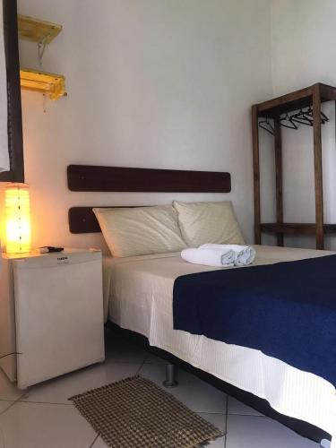 a bedroom with a bed with a blue and white blanket at Céu Azul Pousada in Arraial d'Ajuda
