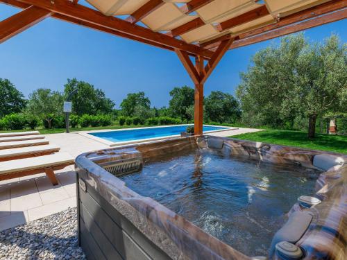 a hot tub in a patio next to a swimming pool at Villa Blog 1 by Interhome in Vošteni