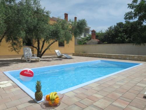 a swimming pool with a pineapple and a ball in it at Holiday Home Tina - BIG120 by Interhome in Biograd na Moru
