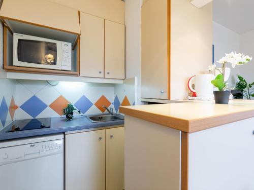 une cuisine avec des armoires blanches et un micro-ondes dans l'établissement Apartment Les Platanes-1 by Interhome, à Sainte-Maxime