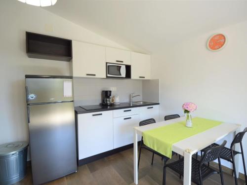 eine Küche mit einem Tisch und einem Kühlschrank in der Unterkunft Apartment Ivka-3 by Interhome in Tribunj