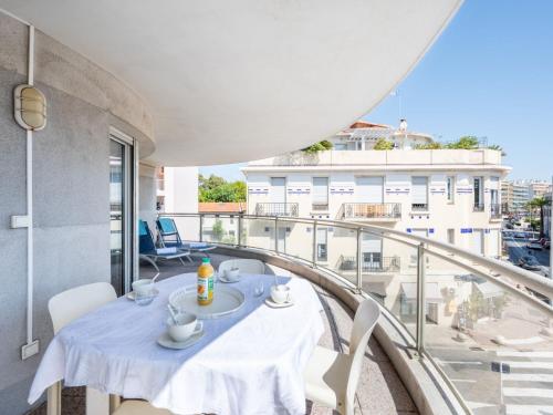 une table avec des tasses et des soucoupes sur un balcon dans l'établissement Apartment Les allées du Cap-2 by Interhome, à Antibes