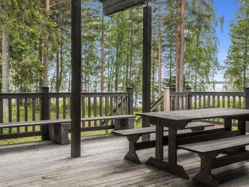 a picnic table and benches on a wooden deck at Holiday Home Pursiranta by Interhome in Keränen