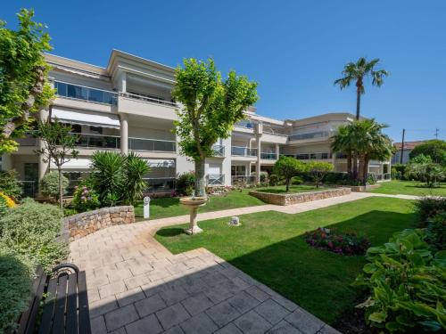 um edifício de apartamentos com um jardim em frente em Apartment Eden Cap by Interhome em Antibes
