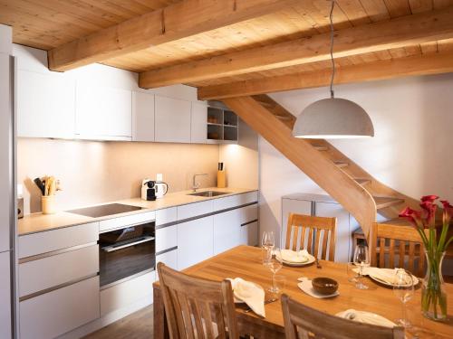 eine Küche und ein Esszimmer mit einem Holztisch in der Unterkunft Apartment Chesa Olgiati by Interhome in Celerina