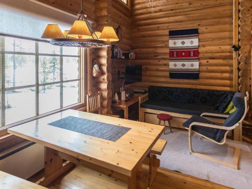 - une salle à manger avec une table et un canapé dans une cabane en rondins dans l'établissement Holiday Home Jänkäluppo i by Interhome, à Äkäslompolo