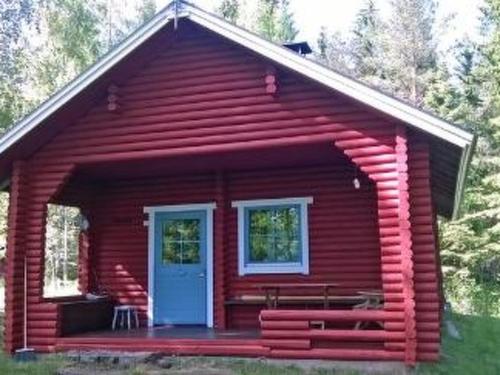a red cabin with a porch and a blue door at Holiday Home Koivuranta by Interhome in Petäjävesi