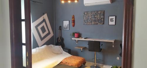 sypialnia z niebieskimi ścianami, łóżkiem i półką w obiekcie Cozy and modern apartment w Korfu