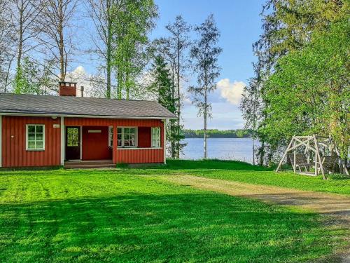 een klein rood huis aan de oever van een meer bij Holiday Home Haukiranta by Interhome in Kittilä