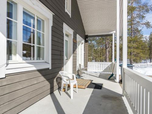 a porch with a white chair on a house at Holiday Home Ylläskankare by Interhome in Äkäslompolo