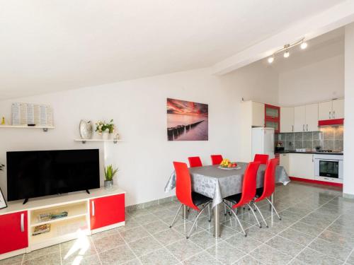 een keuken en eetkamer met een tafel en rode stoelen bij Apartment Niko 1 by Interhome in Duće