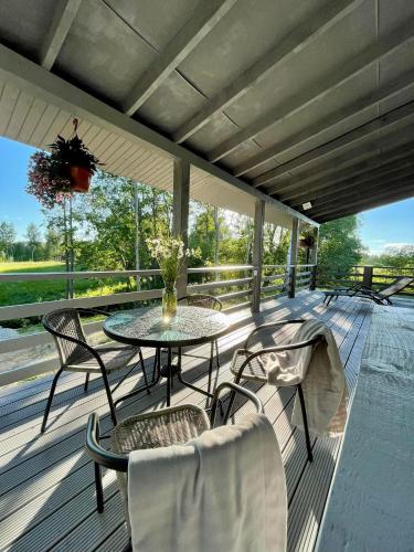 a patio with a table and chairs on a deck at Atpūtas namiņš Jaunlaicenē in Jaunlaicene