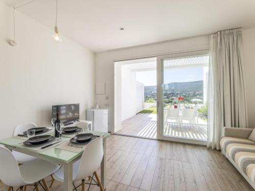 a living room with a table and chairs and a couch at Apartment Capo Falcone Charming Apartment-2 by Interhome in Villa Sirena