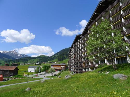 a large building with a tree on the side of it at Apartment Apt B 048 by Interhome in Disentis