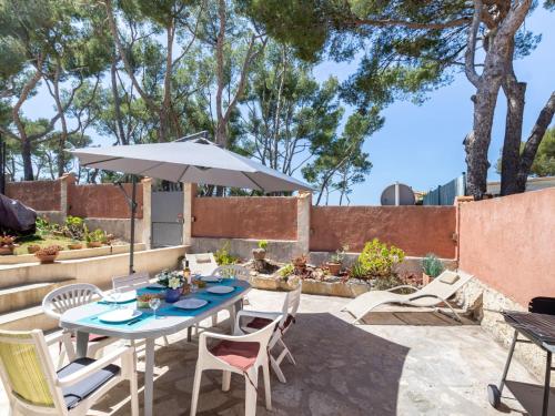 une terrasse avec une table, des chaises et un parasol dans l'établissement Apartment Anaisim by Interhome, à Saint-Cyr-sur-Mer