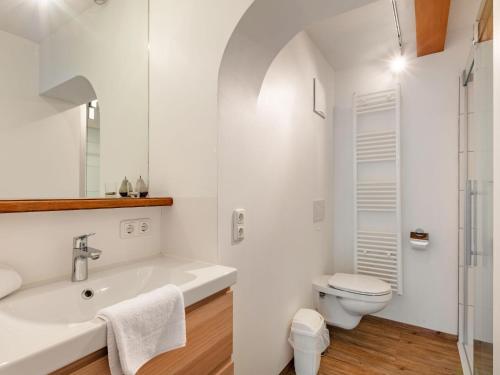 une salle de bain blanche avec une baignoire et des toilettes dans l'établissement Studio Mittagssonne by Interhome, à Neukirchen am Großvenediger