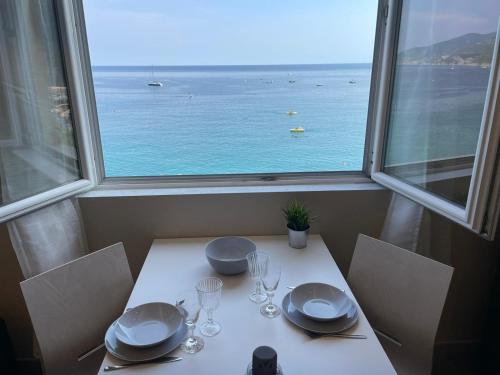 - une table avec des assiettes et des verres à vin devant une fenêtre dans l'établissement Au Mà, à Monterosso al Mare