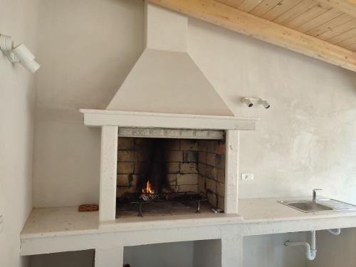- une cheminée en pierre dans une cuisine avec évier dans l'établissement Apartment Nina by Interhome, à Hreljići
