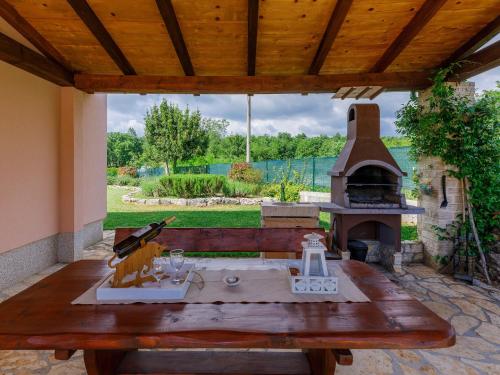a patio with a table and an outdoor oven at Holiday Home Villa Malini by Interhome in Boškari