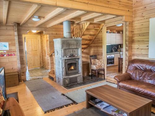 ein Wohnzimmer mit Kamin in einer Blockhütte in der Unterkunft Holiday Home Värikatti by Interhome in Vuokatti