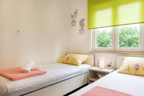 two beds in a room with two windows at Superior Apartment Sincic in Poreč