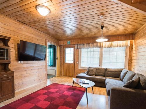 a living room with a couch and a tv at Holiday Home Lomamaja 1 by Interhome in Raattama