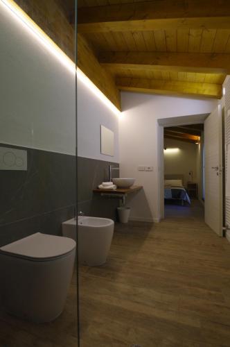 een badkamer met een toilet, een wastafel en een spiegel bij Péstrofa in San Pietro al Natisone