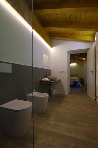 ein Badezimmer mit Toilette, Waschbecken und Spiegel in der Unterkunft Péstrofa in San Pietro al Natisone