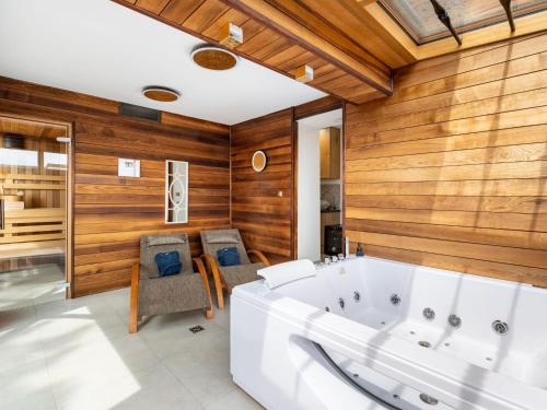 a bathroom with a tub and wooden walls at Chalet Jeschkenpanorama by Interhome in Kurort Oybin