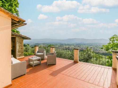 an outdoor deck with chairs and a view at Holiday Home Appartamento Grande by Interhome in Reggello