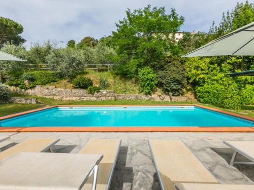 a swimming pool with two chairs and an umbrella at Holiday Home Appartamento Grande by Interhome in Reggello