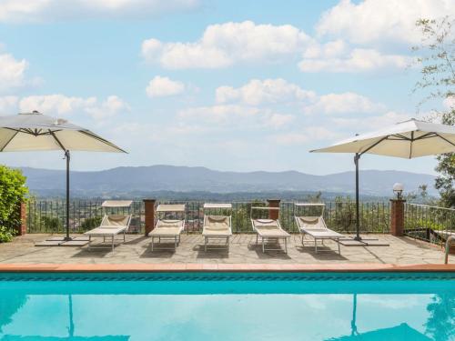 a swimming pool with chairs and umbrellas at Holiday Home Appartamento Grande by Interhome in Reggello