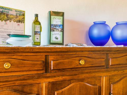 a wooden dresser with two bottles of wine and two vases at Holiday Home Appartamento Grande by Interhome in Reggello