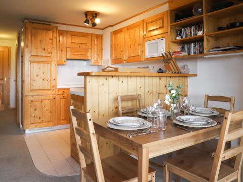 uma cozinha com uma mesa de madeira com placas em Apartment Mandarin 7 by Interhome em Villars-sur-Ollon