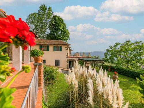 una casa con recinzione e un cortile con fiori rossi di Holiday Home Podere Berrettino by Interhome a Reggello