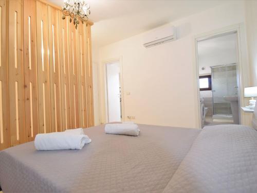 a bedroom with a large bed with two towels on it at Apartment Zagara SinAgo by Interhome in Lascari