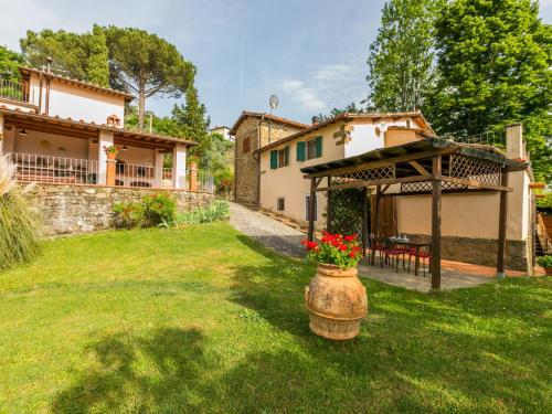 a yard with a house and a table with flowers at Holiday Home Podere Berrettino by Interhome in Reggello