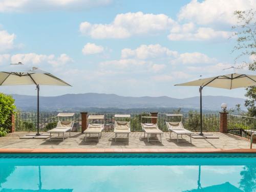 a swimming pool with chairs and umbrellas at Holiday Home Podere Berrettino by Interhome in Reggello